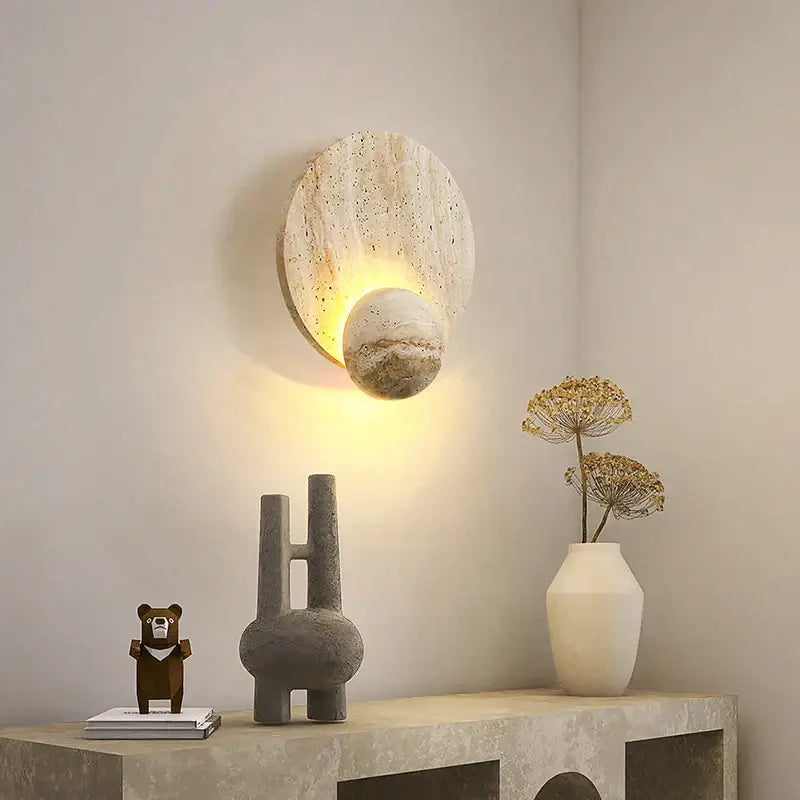 A modern yellow travertine circular led wall light with a speckled beige slab and textured spherical globe for bedroom decorbites wall lights