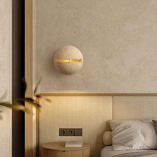 Beige yellow travertine dino egg stone wall lamp with a horizontal gold accent strip by decorbites for bedroom decor
