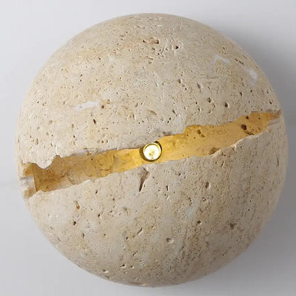 Yellow travertine dino egg stone wall lamp with textured beige surface and gold accent crack by decorbites dino egg wall lamp