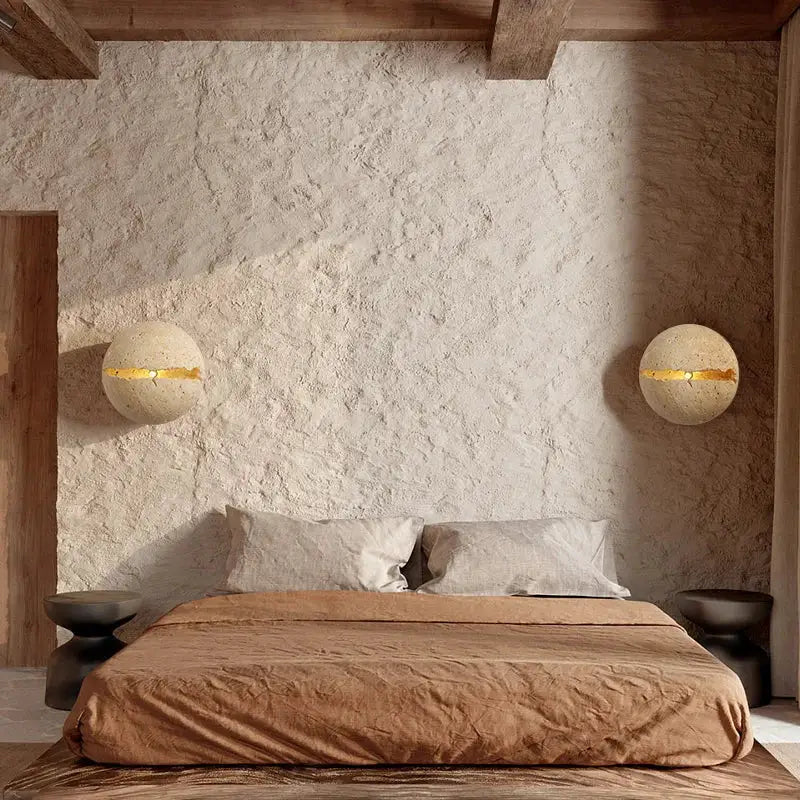 Cream-colored spherical wall lamp with gold accent made of yellow travertine dino egg stone decorbites dino egg sconce