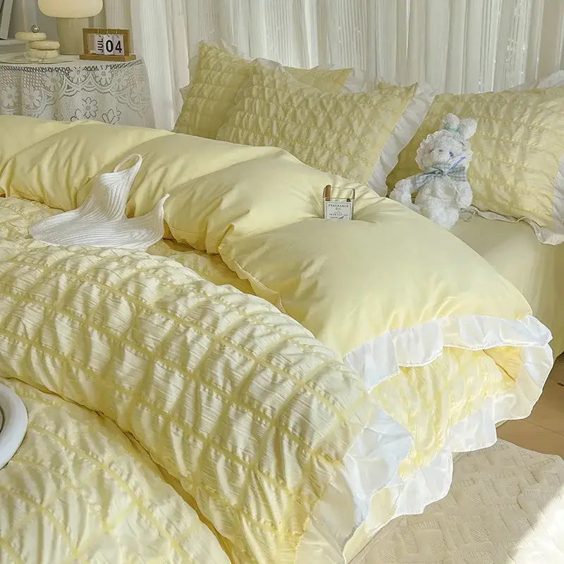 Soft pastel yellow quilted duvet cover set with delicate white ruffled trim in bubble gauze material for bedroom bedding