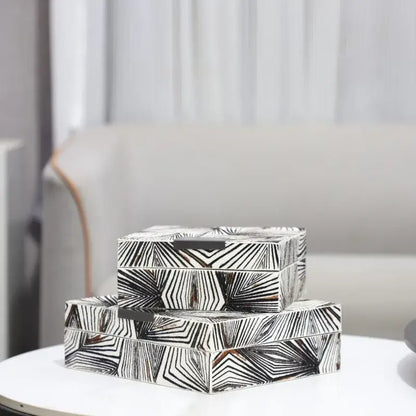 Stacked zebra black and white jewelry storage boxes with bold geometric patterns and a sleek metallic handle for desktop use