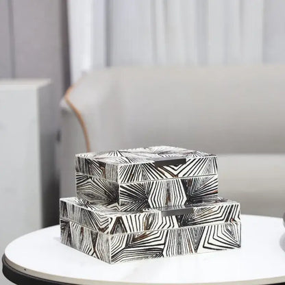 Stacked zebra black and white jewelry storage box with bold geometric patterns and sleek metallic handles for desktop organization