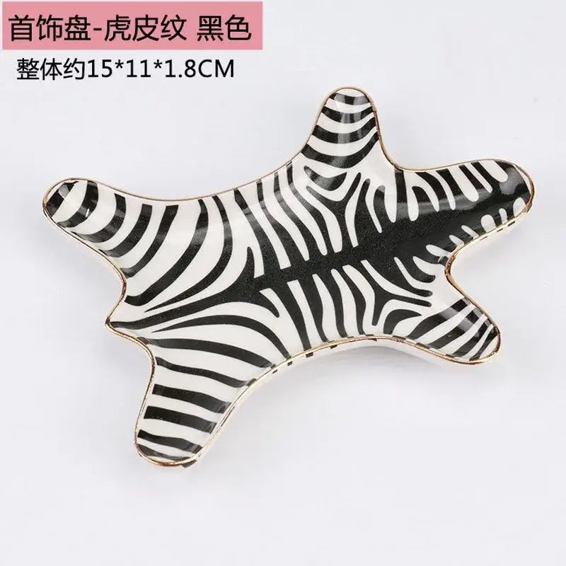 Black and white zebra-striped ceramic jewelry holder tray with gold tiger skin trim for bedroom decor