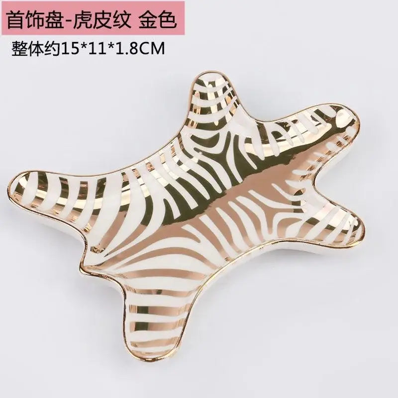 Star-shaped jewelry holder tray with white and gold tiger skin zebra print and shiny gold trim for bedroom decor