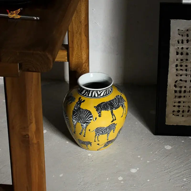 A vibrant yellow ceramic zebra yellow vase with black and white zebra illustrations and artificial flowers for desk decoration